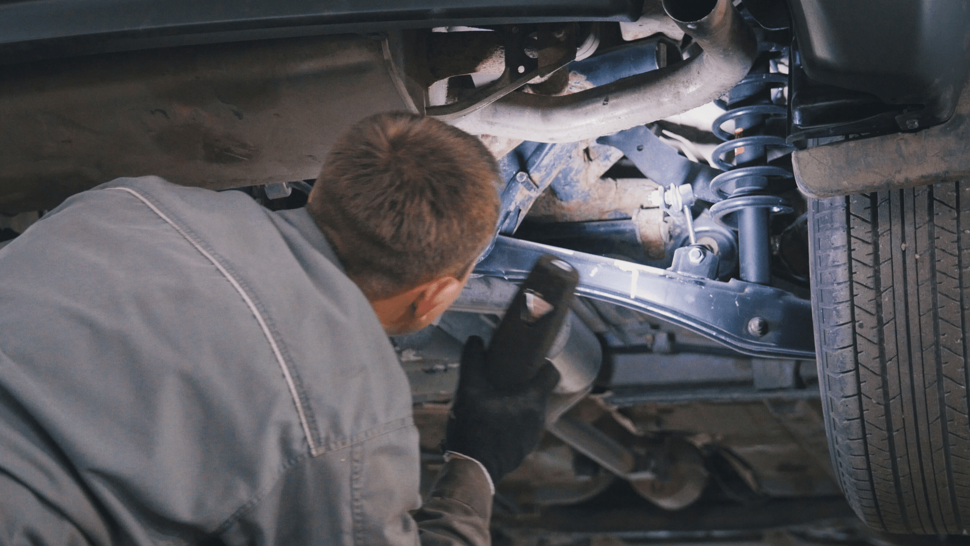 Delphi Expert using a torch to investigate the suspension of a car.